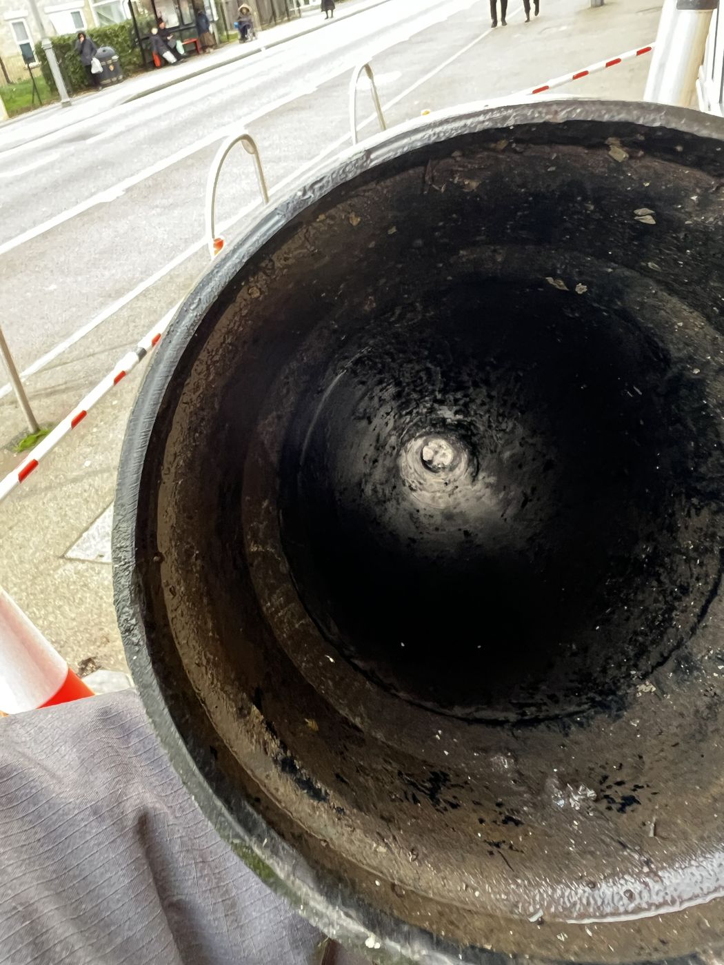 Looking down into a cleared cast iron hopper head with the outlet visible at the base