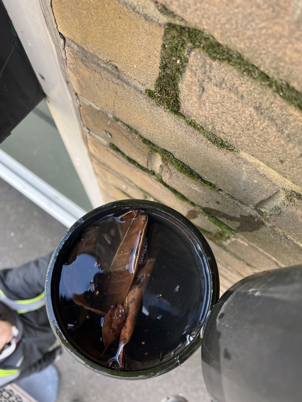 Hopper head at high level full of standing black water with debris floating in it