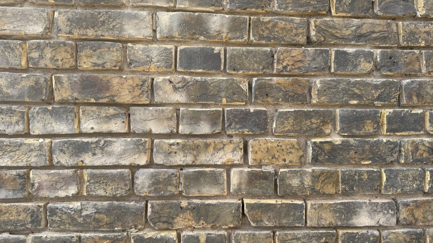 Eroded mortar joints in yellow London stock brick before repointing