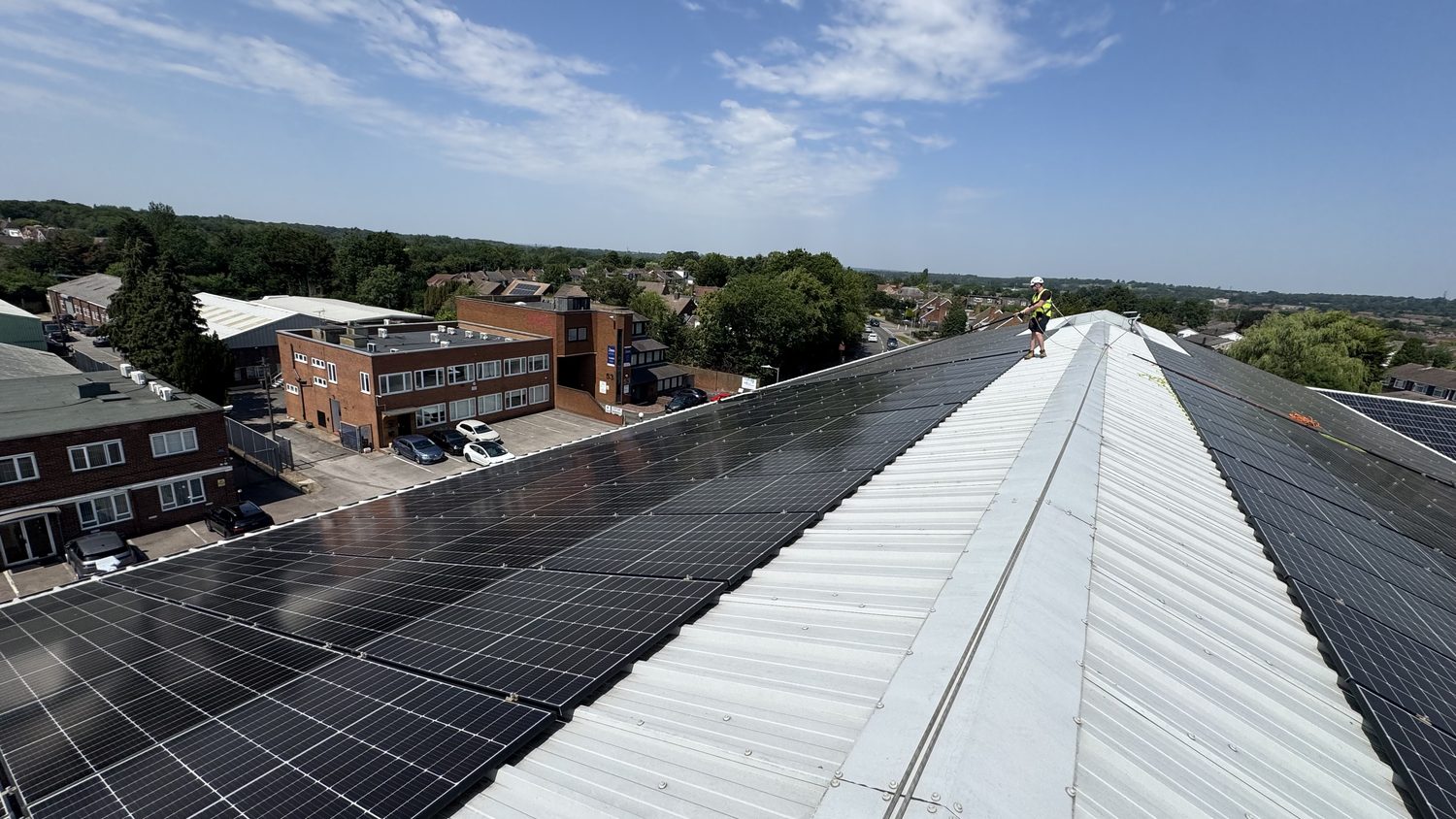 Commercial rooftop solar array covering both slopes of an industrial roof in Borehamwood