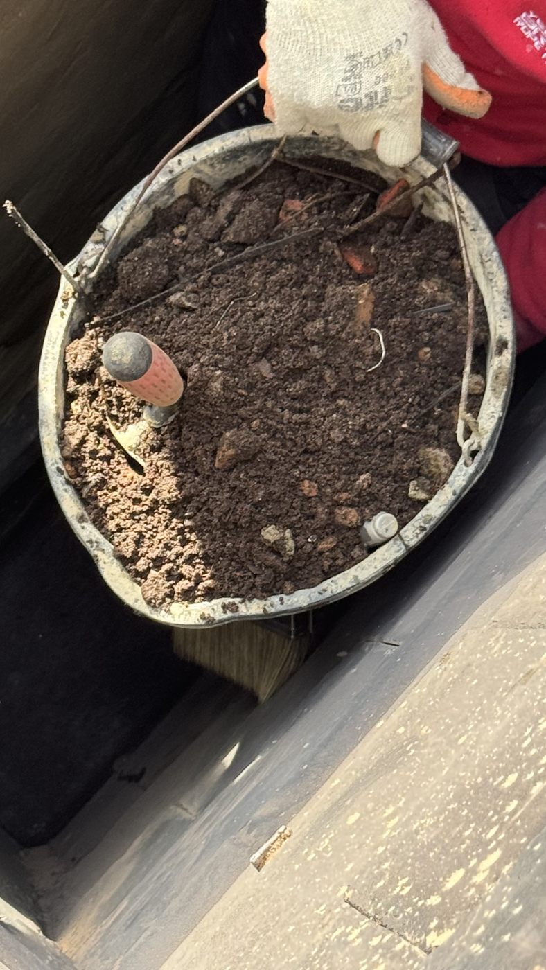 Bucket of silt and debris removed from a high level gutter